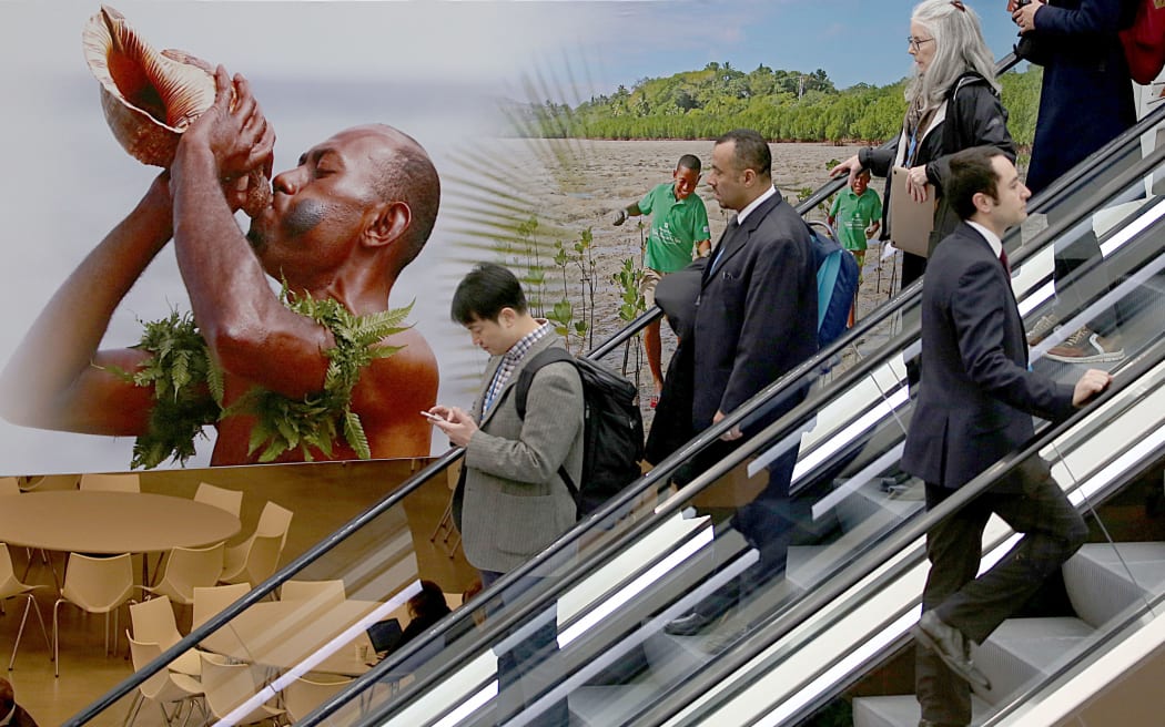 Visitors use an escalator past a poster featuring the Fiji Islands on the opening day of the COP 23 United Nations Climate Change Conference on November 6, 2017 in Bonn, Germany.