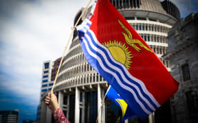 The Kiribati flag is waved in front of the Beehive in Wellington.