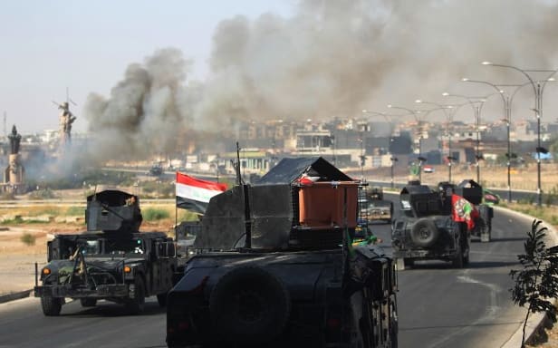 Smoke billows as Iraqi forces advance towards the centre of Kirkuk.