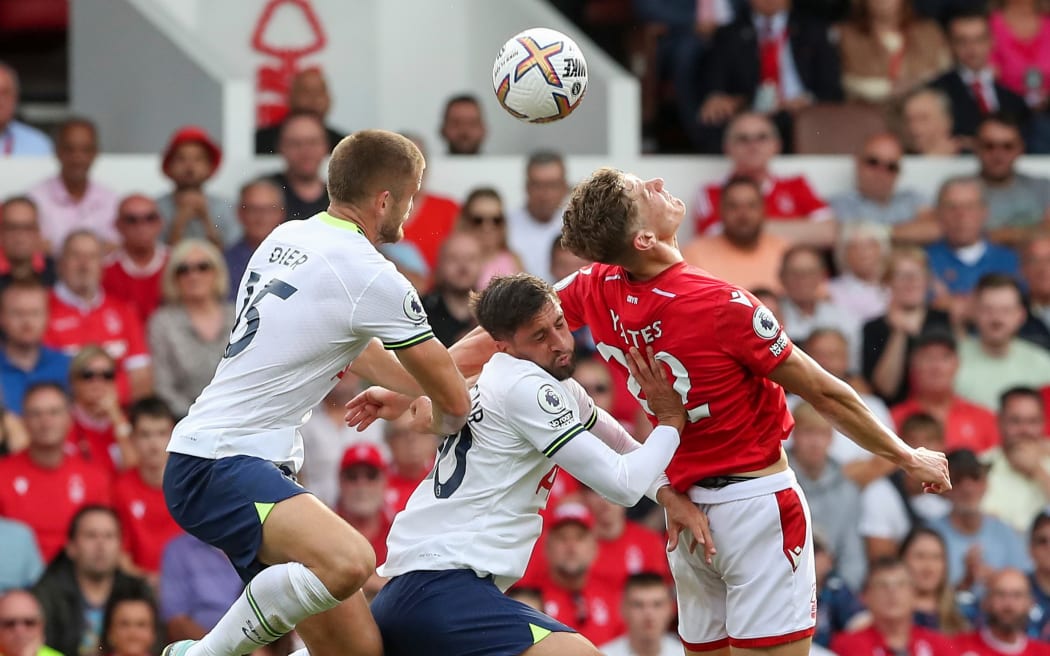 Nottingham Forest and Tottenham Hotspur players contest possession.