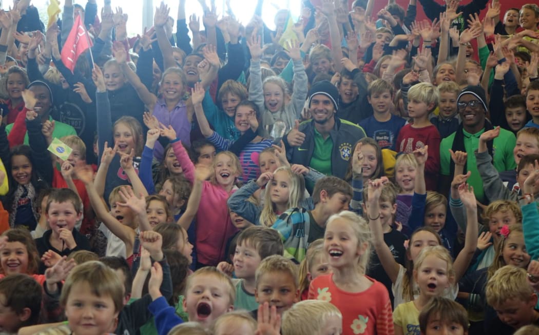 Brazilian players Jaja, Caju and Marcos are mobbed at Oakura Primary School southwest of New Plymouth.