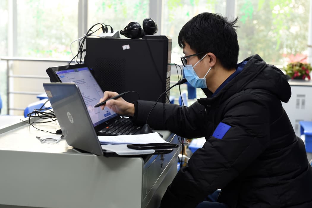 Physics teacher Li Wenzhi gives an online tuition to students at Hefei No. Eight Senior High School in Hefei, east China's Anhui Province, Feb. 3, 2020.