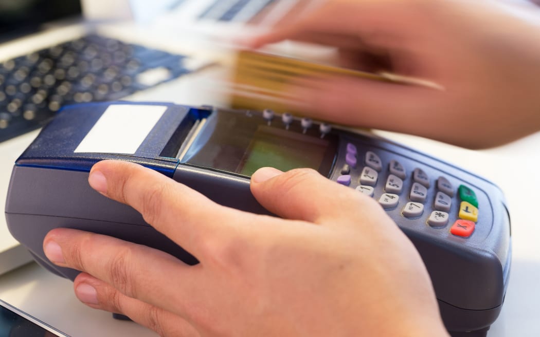 An EFTPOS card being swiped at a terminal.