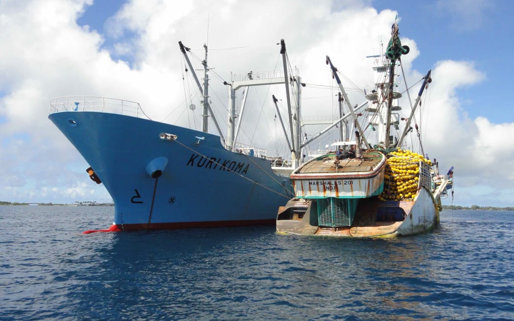 เรืออวนล้อมจับปลาทูน่า Marshall 201 ซึ่งผูกติดอยู่กับเรือขนส่งปลาทูน่าทางด้านขวา เป็นหนึ่งในเรือหลายพันลำทั่วโลกที่จดทะเบียนในหมู่เกาะมาร์แชลล์ ซึ่งดำเนินการจดทะเบียนเรือใหญ่เป็นอันดับสามของโลก