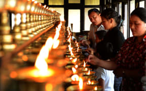 Family members of the Everest avalanche victims light oil lamps at Sherpa Monastery in Kathmandu.