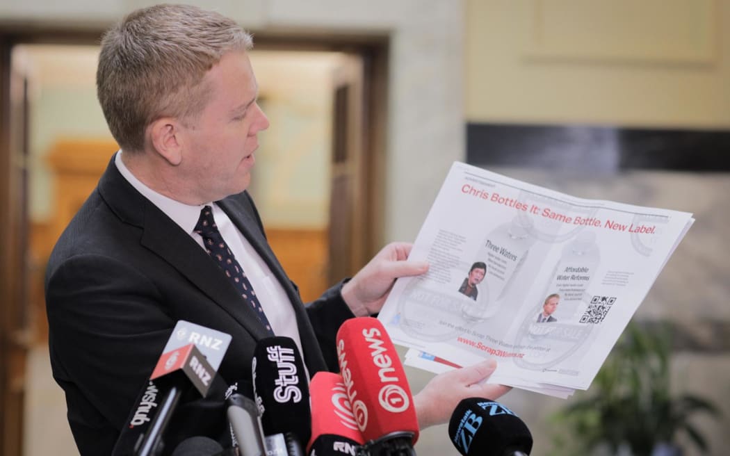 Labour Leader Chris Hipkins holds up a series of attacks ads which mention him or other Labour MPs. He says they have been shared by National and/or its MPs.