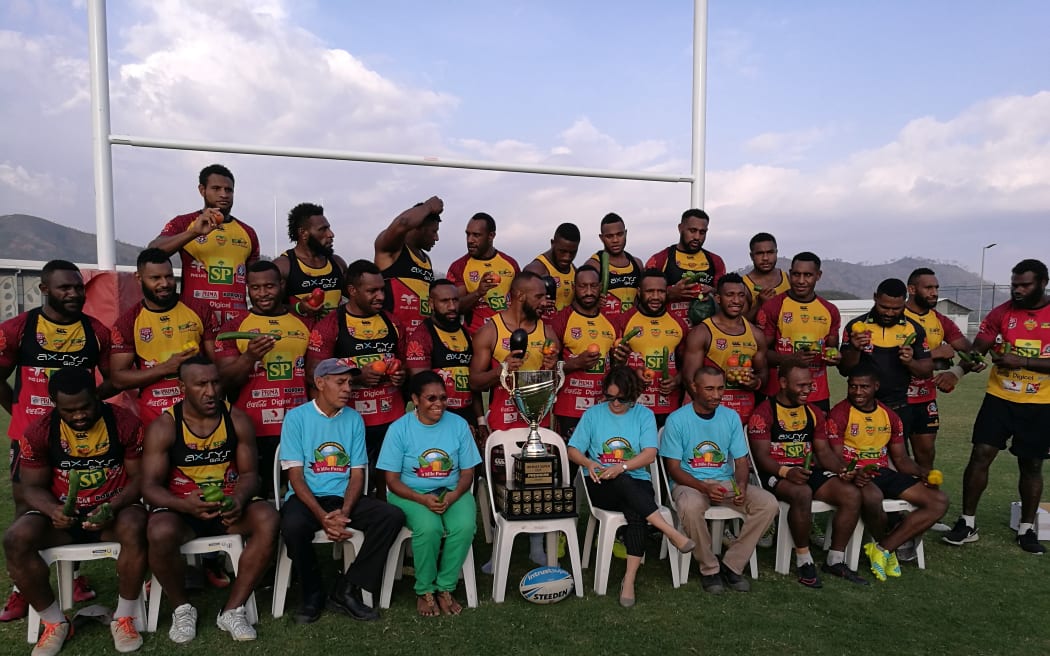 The PNG Hunters squad pose with the Intrust Super Cup trophy in Port Moresby.