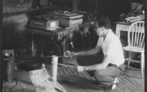 Douglas Lilburn recording the sound of struck sheets of steel and other items on to magnetic tape, in a barn in Wiltshire, England, circa 1963.