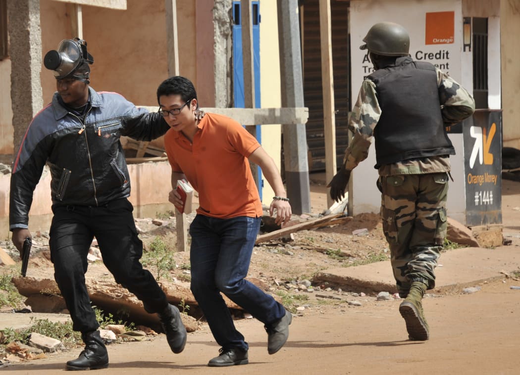 Malian security forces evacuate a man from an area surrounding the Radisson Blu hotel in Bamako