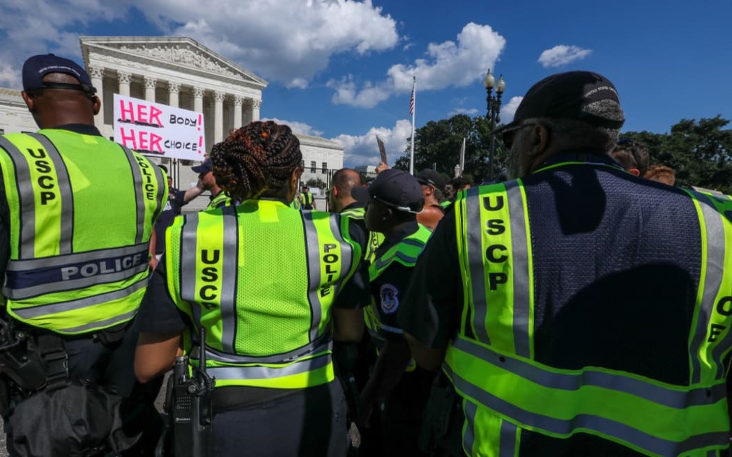 Police officers outside the US Supreme Court, where protests are continuing.