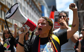 Protesters take part in an "Invasion Day" demonstration on Australia Day in Sydney on January 26, 2022. (Photo by Steven Saphore / AFP) (Photo by STEVEN SAPHORE/AFP via Getty Images)