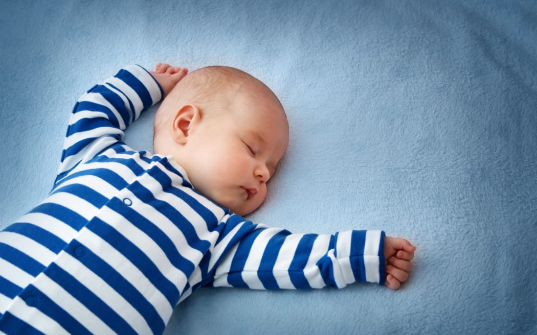 little boy sleeping on soft blue blanket