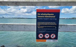 A sign warns locals against swimming and fishing at Okahu Bay.