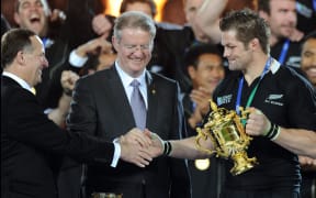 Dubbed the three-way handshake: IRB boss Bernard Lapasset, PM John Key and All Blacks captain Richie McCaw with the Webb Ellis Cup at the conclusion of the 2011 Rugby World Cup.