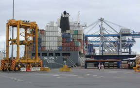 Cranes and container movers work to laod a ship at the Ports of Auckland