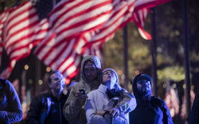 People watch the midterm election primary results on a screen at the Rockefeller Center in New York.