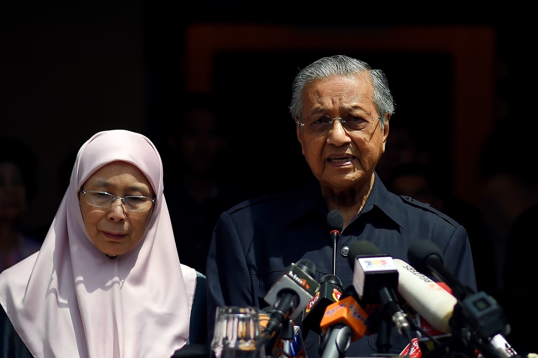 Newly-elected Malaysian Prime Minister Mahathir Mohamad (R) addresses the media next to Wan Azizah, the wife of jailed former opposition leader and current Federal opposition leader Anwar Ibrahim