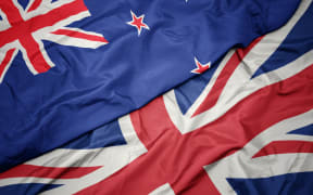 waving colorful flag of great britain and national flag of new zealand. macro