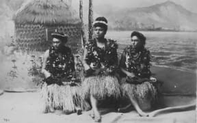 Hawaiian hula girls playing the ukulele popularized in the reign of King Kalakaua.