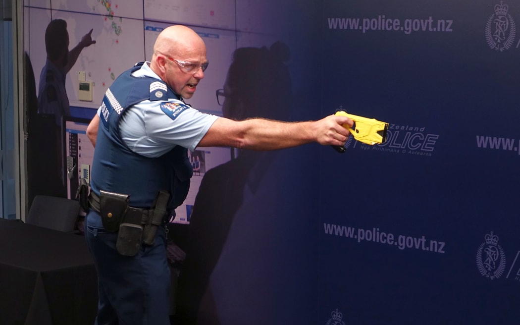 Sergeant Darrin Putt demonstrates the use of a taser.