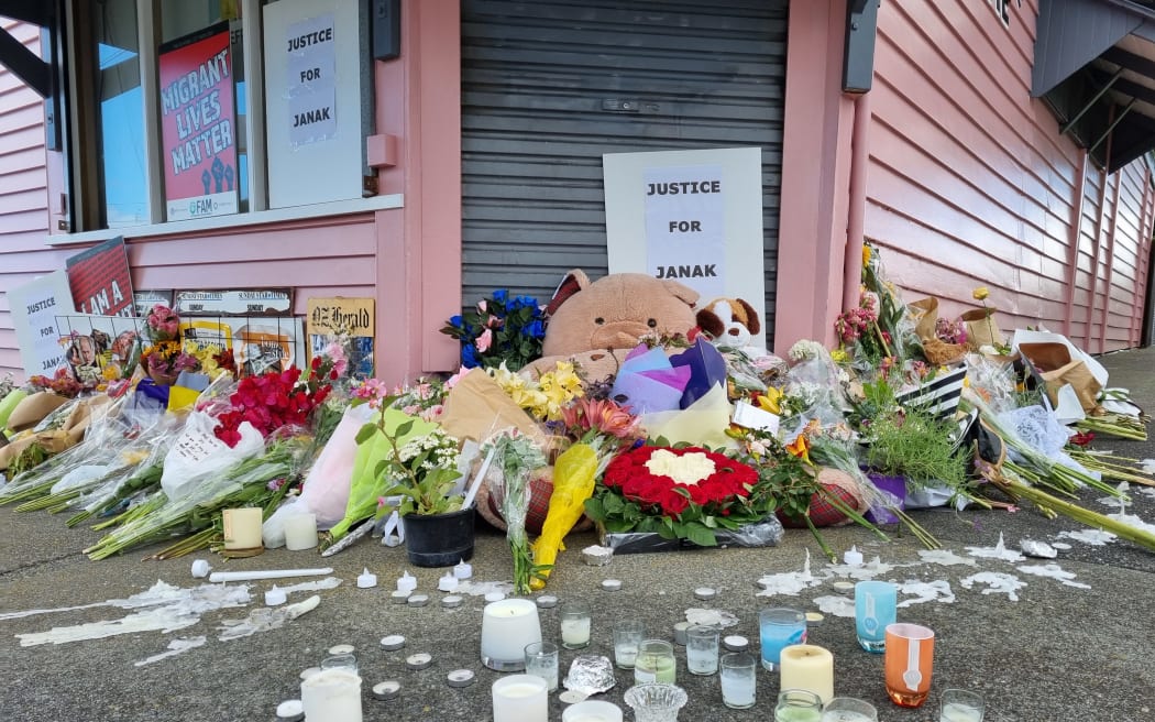 A sign reading 'Justice for Janak' among flowers and candles outside the Rose Cottage Supererette in Sandringham, 28 November, 2022.