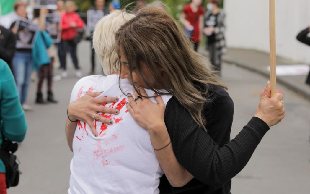 Two protesters embrace during a demonstration outside the Iranian embassy in Wellington on 28 October, 2022.