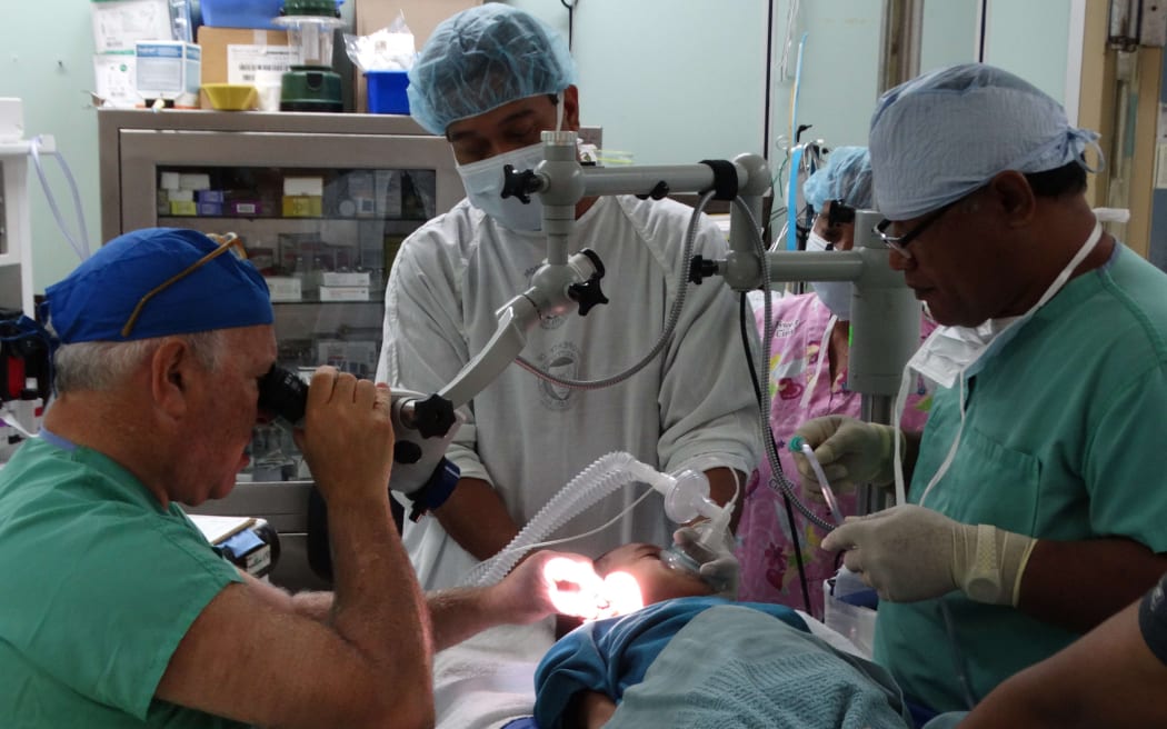 Visiting ENT specialist Dr. Richard Wagner, left, performs an ear procedure on a young Marshall Islander with the assistance of Majuro hospital staff in this file photo from 2015.