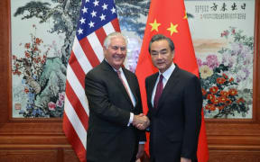 US Secretary of State Rex Tillerson shakes hands with Chinese Foreign Minister Wang Yi.