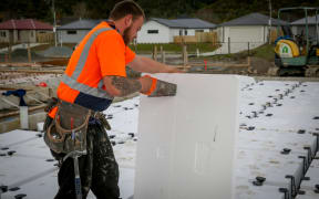 A builder cutting polystyrene used for insulation and foundation footings on a new home in Upper Hutt.