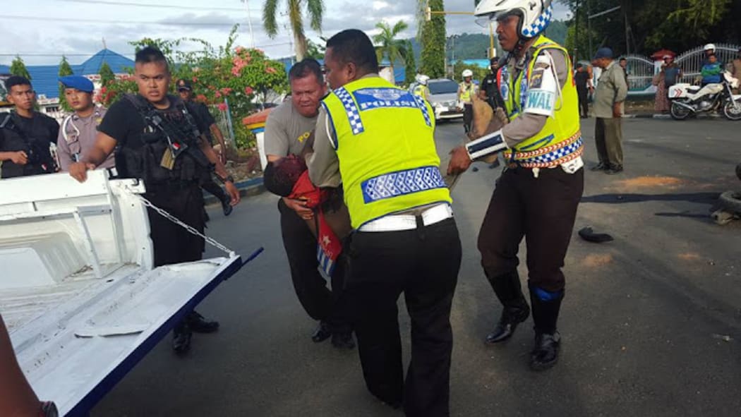 Indonesian police and security forces gather the body of West Papuan teenager Owen Pekei.