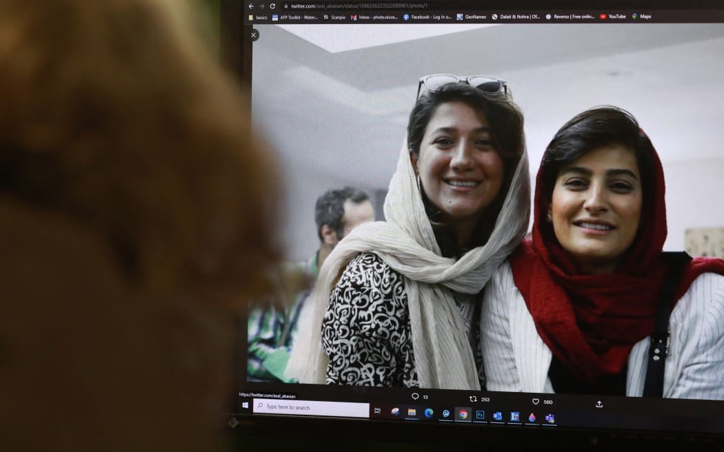 A woman looks at a picture of Iranian reporters Niloufar Hamedi and Elahe Mohammadi posted on twitter, in Nicosia on November 2, 2022. Concern is growing over the fate of the two Iranian reporters who helped bring the world’s attention to the death of Mahsa Amini but have been jailed for the past month and are now targeted by what activists see as a smear campaign to portray them as spies. (Photo by Christina ASSI / AFP)