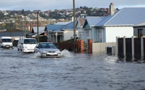 A car powers through floodwaters in south Dunedin on Thursday.