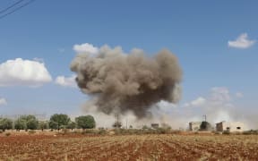 Smoke billows following Syrian government forces' bombardment around the village of al-Muntar