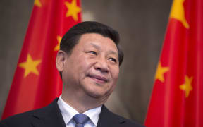 Chinese president Xi Jinping is framed by national flags during an overseas visit, to Berlin on 28 March 2014.