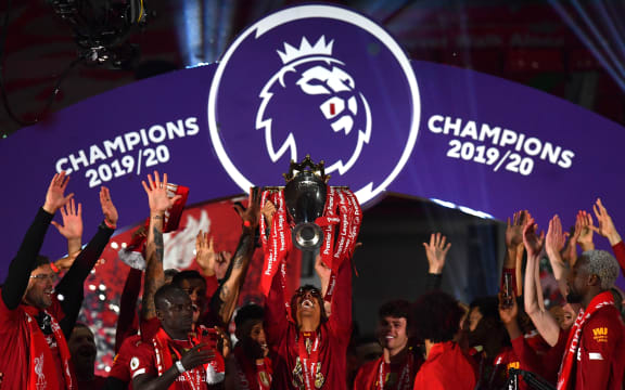 Liverpool's Brazilian midfielder Roberto Firmino (C) lifts the Premier League trophy during the presentation following the English Premier League football match between Liverpool and Chelsea at Anfield in Liverpool, north west England on July 22, 2020.