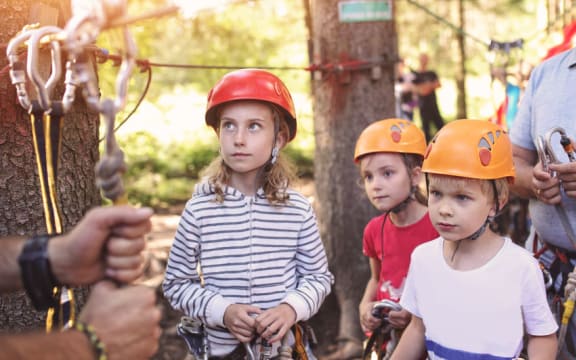 A Photo of a group of girls learning to climb on an adventure course