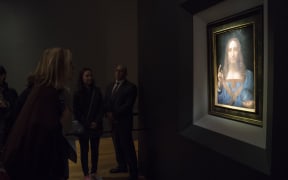 Visitors view the painting 'Salvator Mundi' by Leonardo da Vinci at Christie's New York Auction House.