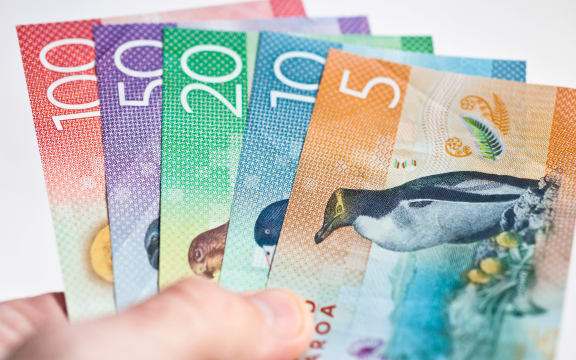 New Zealand currency held fanned out in someones hand