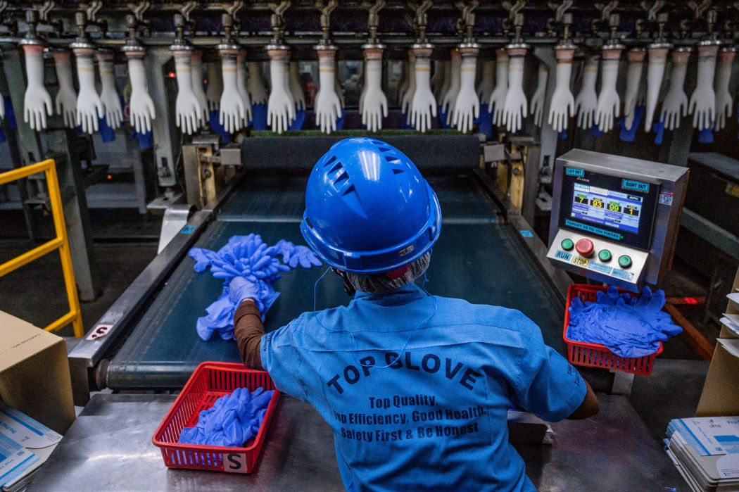 A worker inspects disposable gloves at the Top Glove factory in Shah Alam on the outskirts of Kuala Lumpur on August 26, 2020.