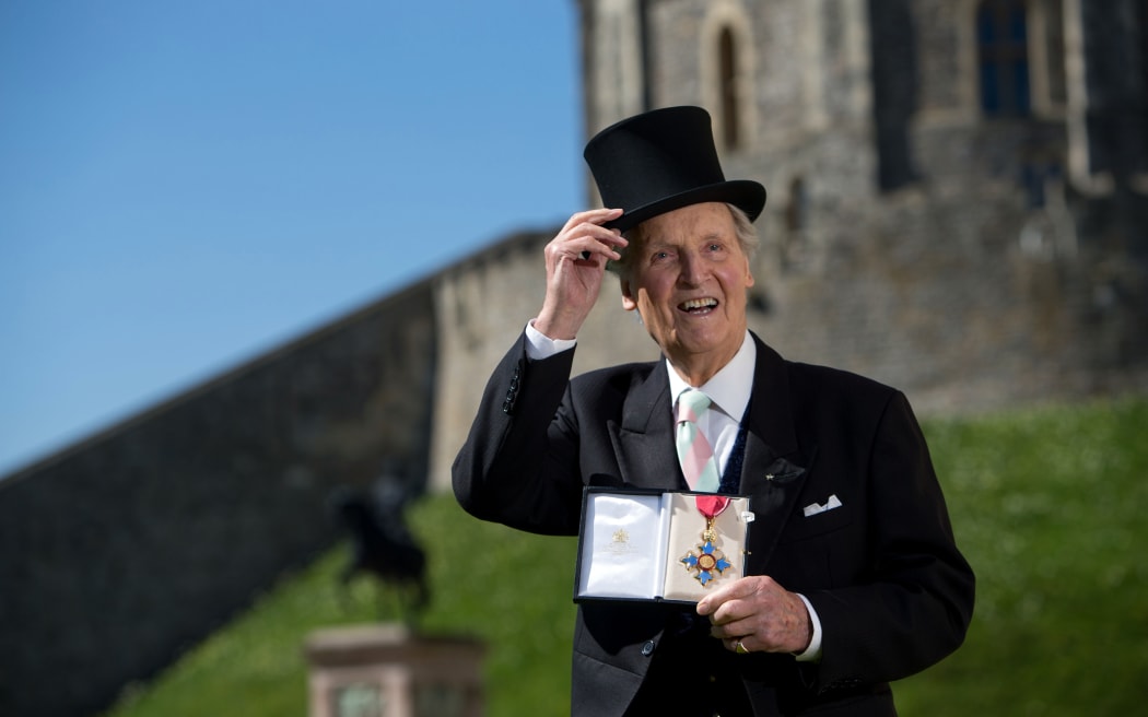 British radio and television presenter Nicholas Parsons poses with his Commander of the Order of the British Empire (CBE) medal given to him by Queen Elizabeth II at an Investiture ceremony at Windsor Castle in 2014.