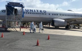 United Airlines workers in Majuro wore full-body PPE before going onto a United flight in May