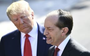 US President Donald Trump (L) listens to US Labor Secretary Alexander Acosta as he speaks to the media early July 12, 2019 at the White House in Washington, DC.