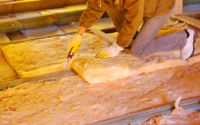 13174303 - construction worker thermally insulating house attic with glass wool