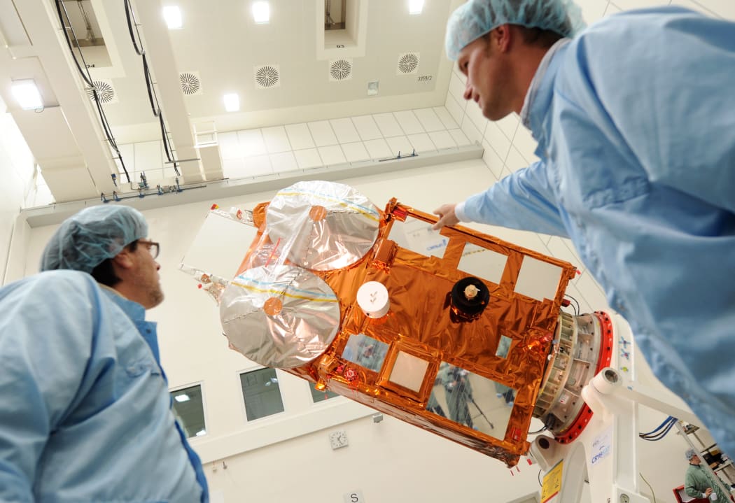 Visitors and members of the CryoSat-2 project view the satellite in a cleanroom of space technology company IABG in Germany, 2009.
