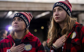 DULUTH, MN - SEPTEMBER 30: Holly Holly (L), and her daughter Sydney Holly, hold their hands over their hearts during the singing of the national anthem during a campaign rally for President Donald Trump at the Duluth International Airport on September 30, 2020 in Duluth, Minnesota.