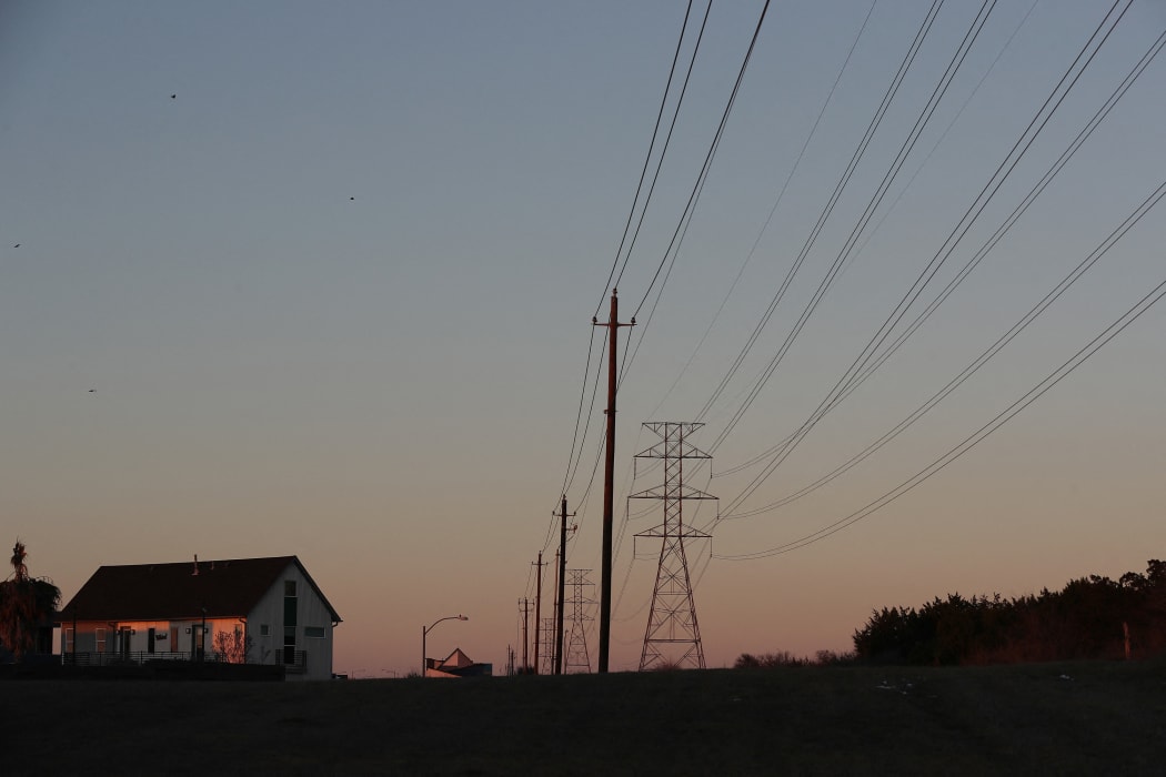 File photo. Electric power lines run through a neighborhood in Austin, Texas, 19 February.