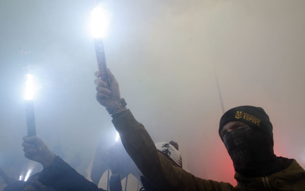 Ukrainian nationalists burn flares during a rally, demanding the government break the agreement between Ukraine and Russia on cooperation in the use of the sea of Azov and the strait of Kerch and set martial law in the country.