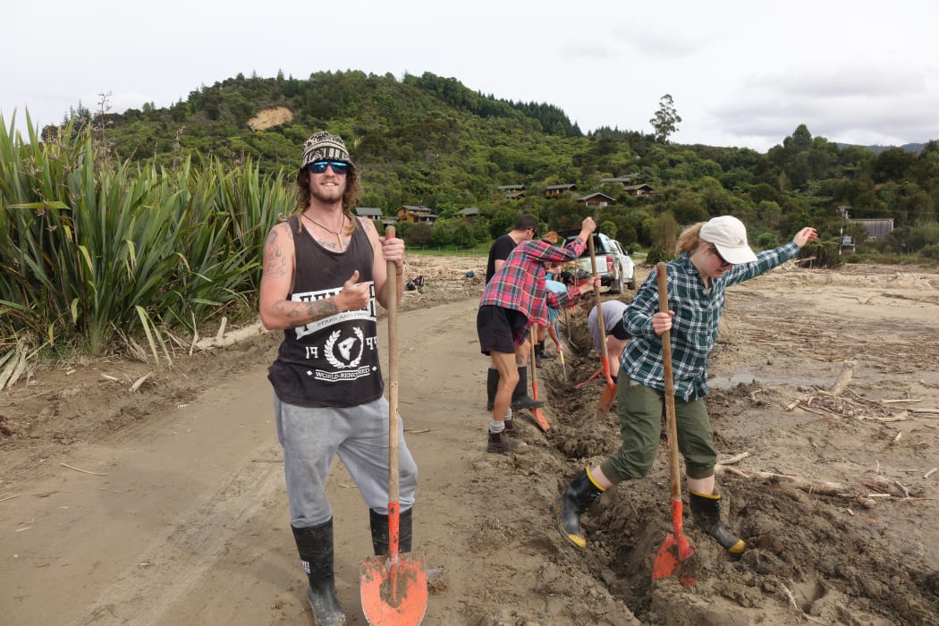Volunteers help clear mud and debris a week after the storm.