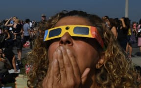 Cherri Haghighit views the start of the total solar eclipse at the Griffith Observatory in Los Angeles, California, on August 21, 2017.