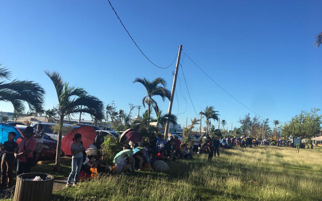 People lining up in the heat in the CNMI to get food stamps.